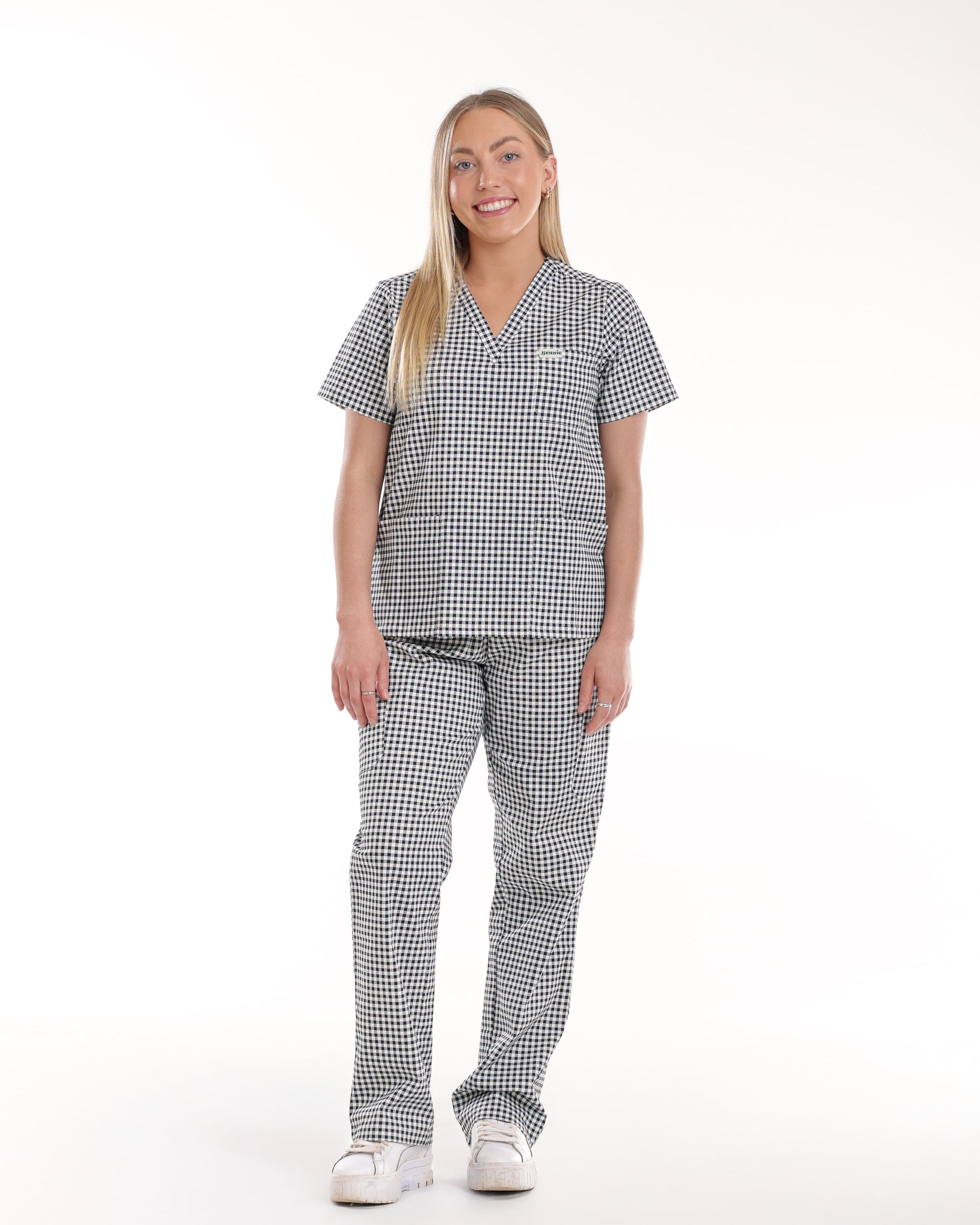 Model wearing Bennie Frankie Scrub Set in black and white gingham print, showcasing full outfit with short sleet top and straight-leg pants 
