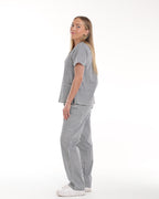 Side full body view of Model wearing Bennie Frankie Scrub Set in black and white gingham print, showcasing full outfit with short sleet top and straight-leg pants 