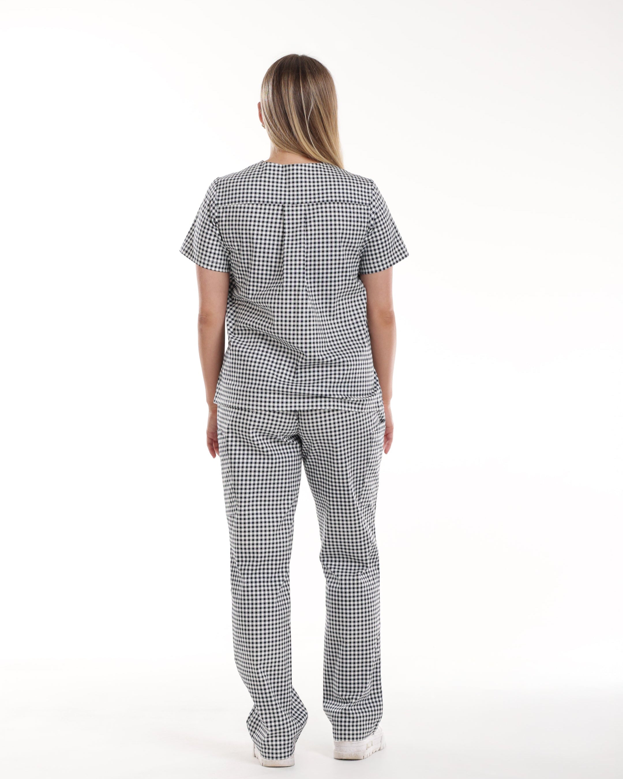 Back view of Model wearing Bennie Frankie Scrub Set in black and white gingham print, showcasing full outfit with short sleet top and straight-leg pants 