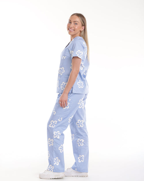 Side view of Bennie Daisy Scrub Set in blue floral print, showcasing fit and design of medical scrubs. 
