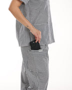 Side view of Bennie Frankie Scrub Set in black and white gingham, featuring functional pocket detail holding a phone.