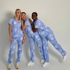 Three models wearing Bennie Daisy Scrub Set in blue floral print form the Debut Collection, styled together for campaign photography
