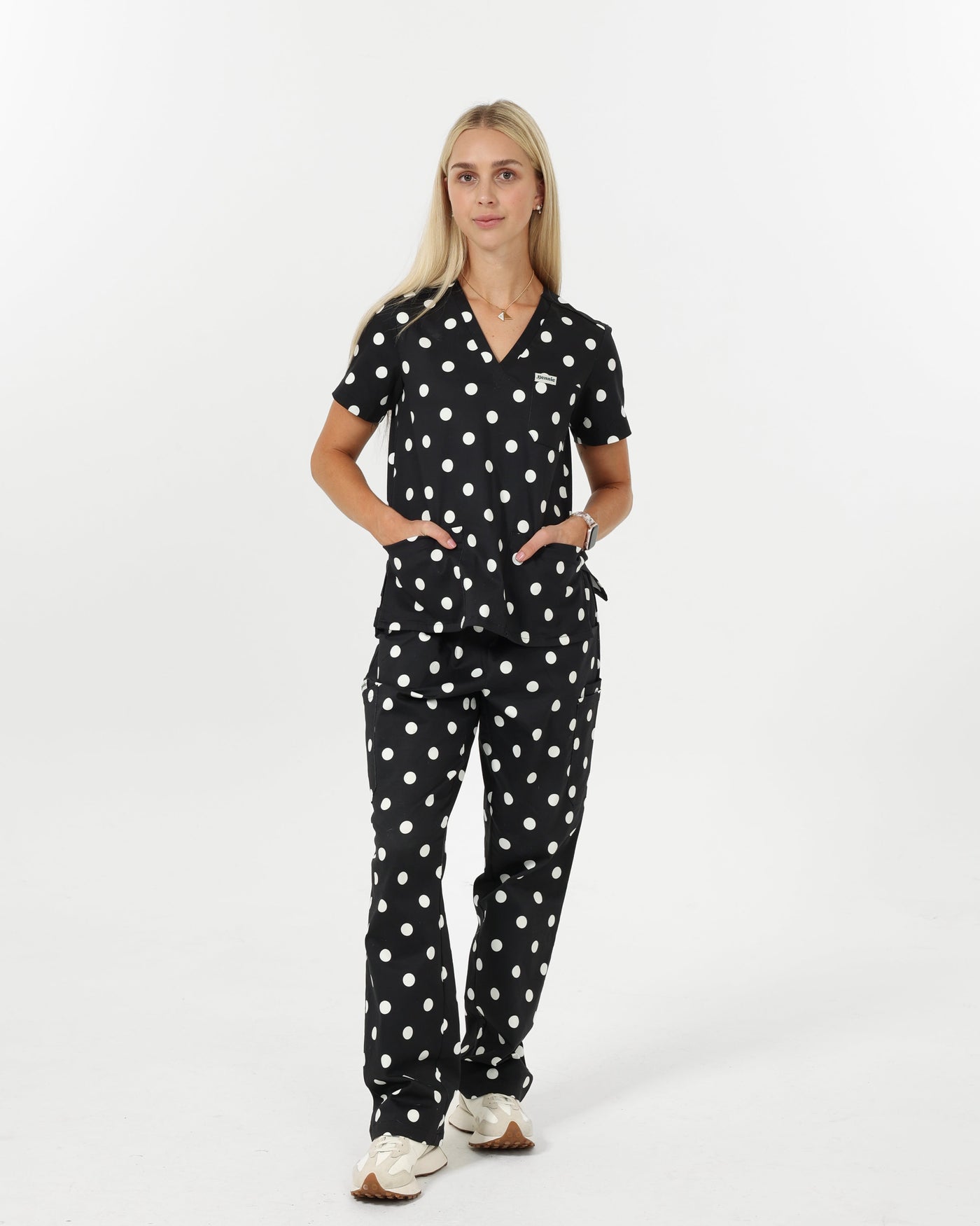 Woman wearing a black polka dot scrubs on a white background